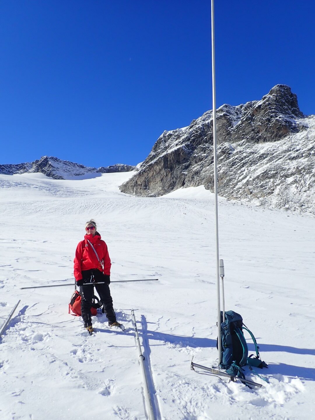 Bilde av en person som gjør målinger på en isbre.